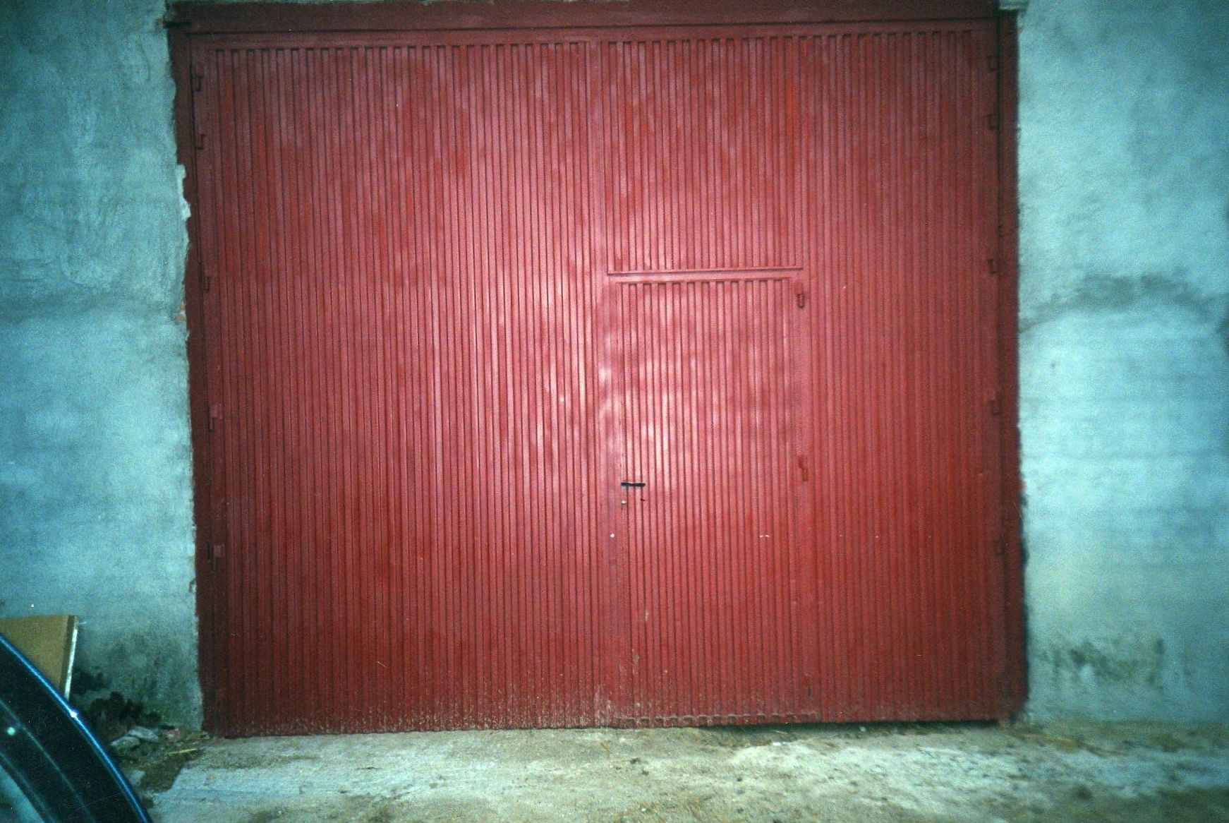 Puerta industrial de dos hojas batientes, con puerta de servicio incorporada Puerta industrial de dos hojas batientes, con puerta de servicio incorporada