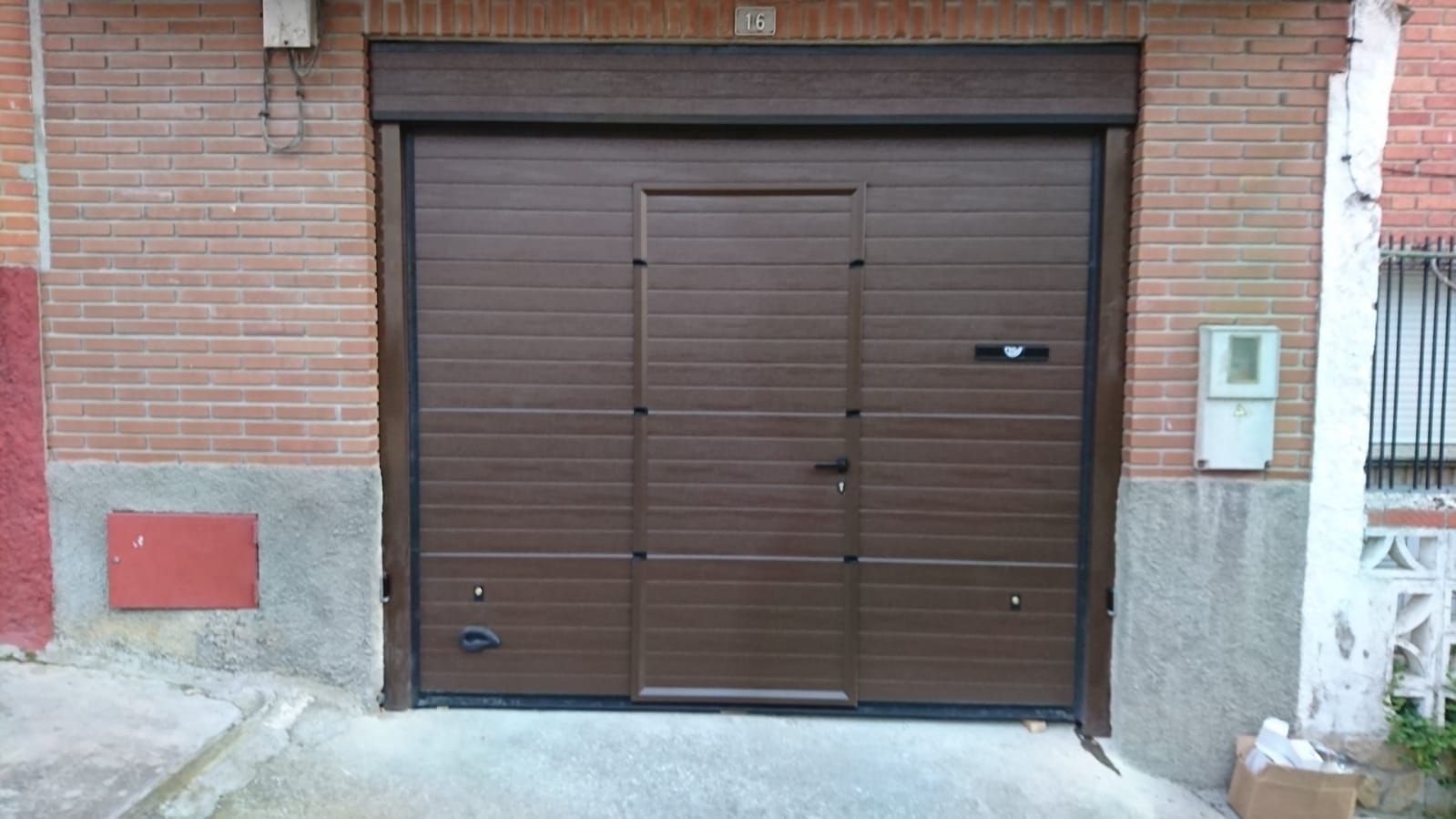 Puerta seccional con puerta de servicio, motorizada Puerta seccional con puerta de servicio, motorizada