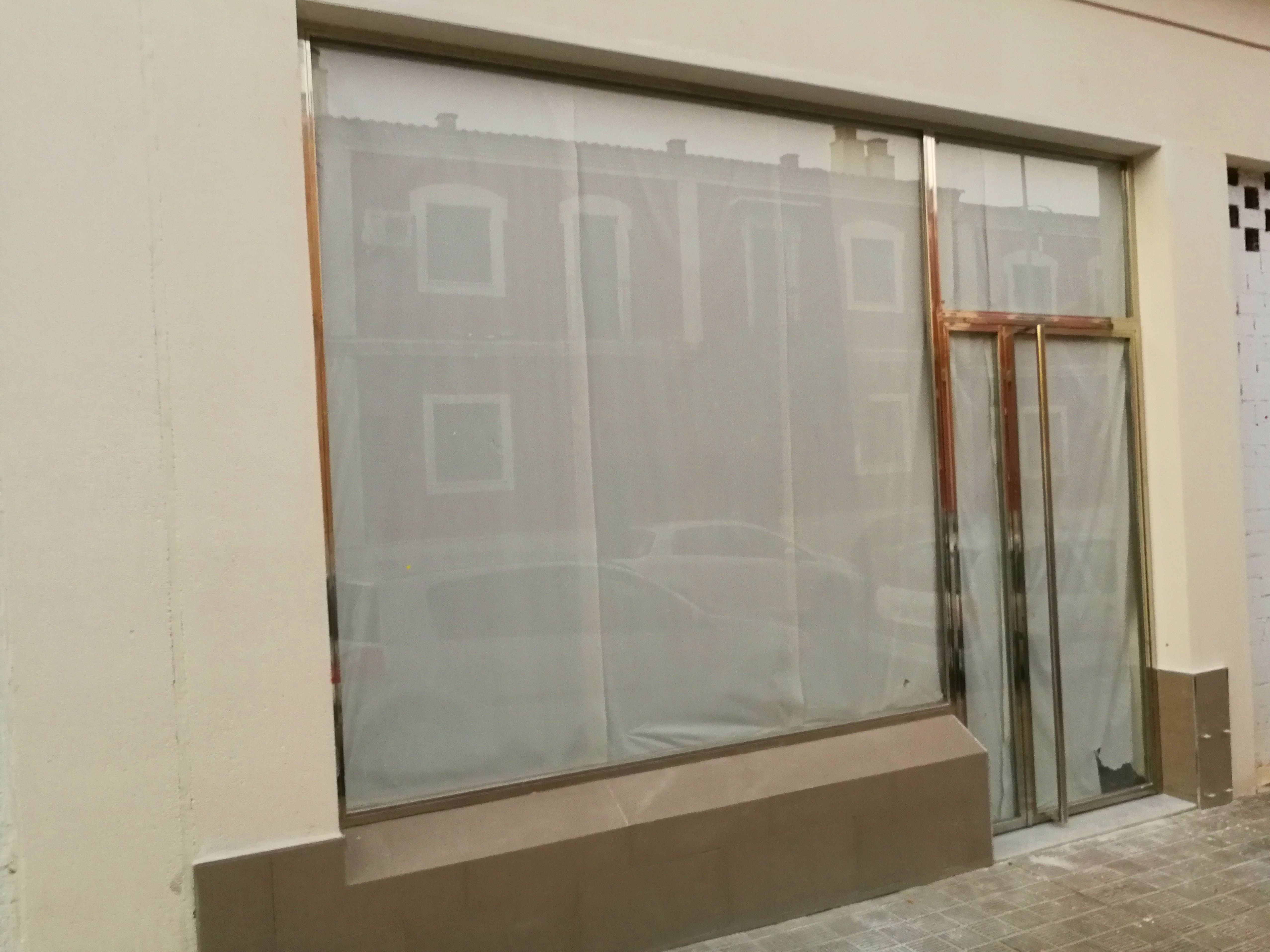 Puerta y escaparate de acero inoxidable y vidrio diseñada y fabricada a medida para local comercial Puerta y escaparate de acero inoxidable y vidrio diseñada y fabricada a medida para local comercial