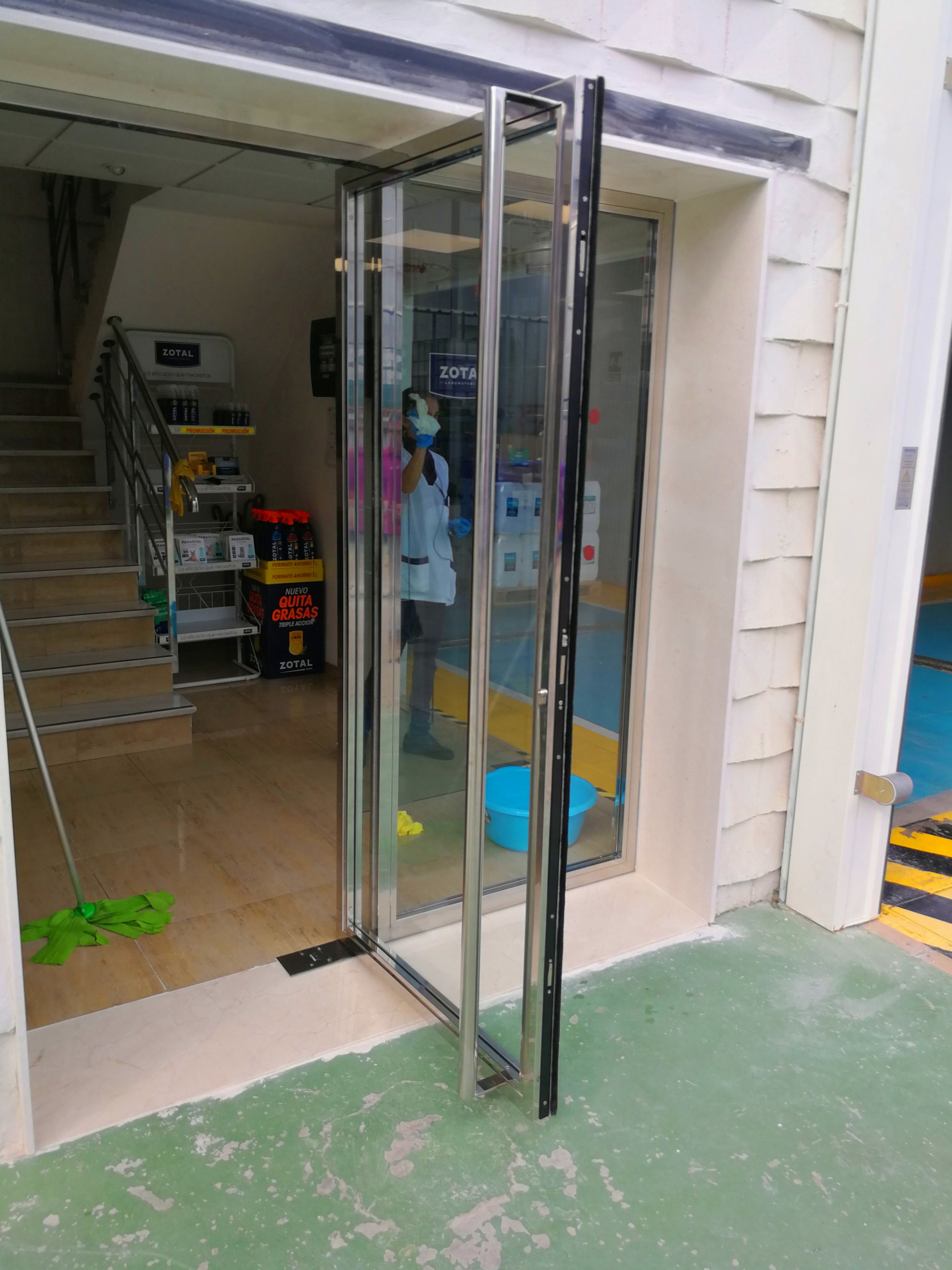 Puerta de acero inoxidable y vidrio diseñada y fabricada a medida para edificio empresarial de zona industrial. Puerta de acero inoxidable y vidrio diseñada y fabricada a medida para edificio empresarial de zona industrial.