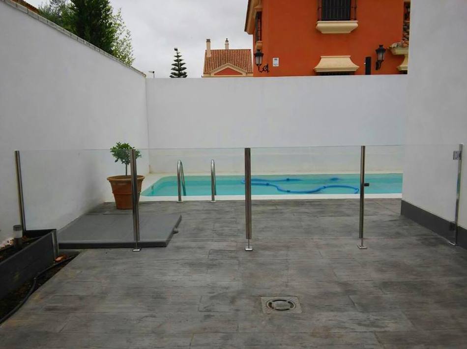 Barandilla de acero inoxidable y vidrio con puerta de acceso a piscina diseñada y fabricada a medida para vivienda particular Barandilla de acero inoxidable y vidrio con puerta de acceso a piscina diseñada y fabricada a medida para vivienda particular