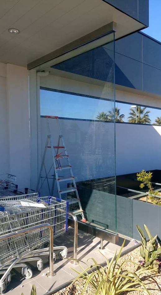 Mampara de vidrio con soportes de acero inoxidable diseñado y fabricado a medida y montado en centro comercial. Mampara de vidrio con soportes de acero inoxidable diseñado y fabricado a medida y montado en centro comercial.