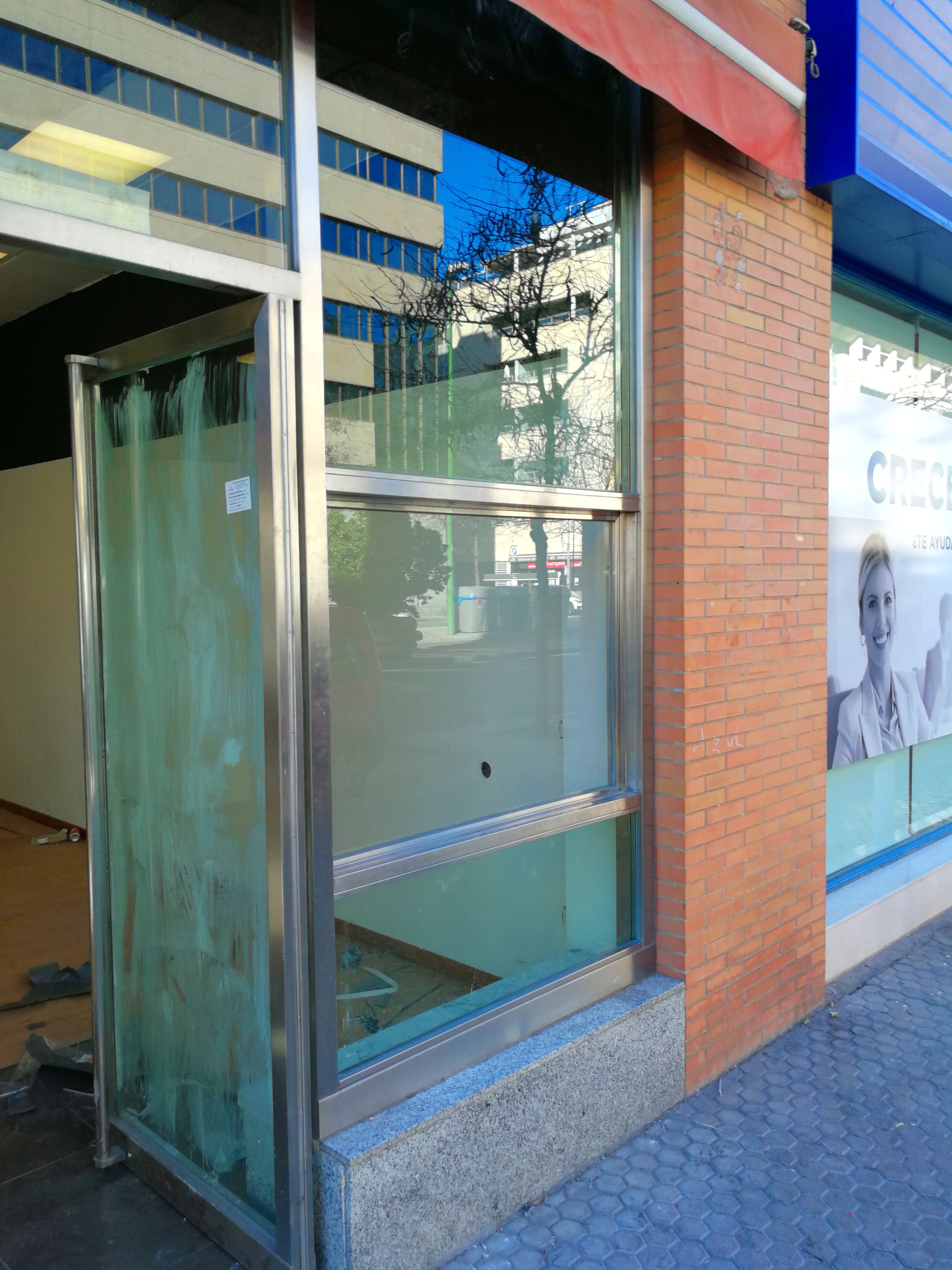 Ventana guillotina de acero inoxidable y vidrio montada para escaparate de local comercial. Ventana guillotina de acero inoxidable y vidrio montada para escaparate de local comercial.