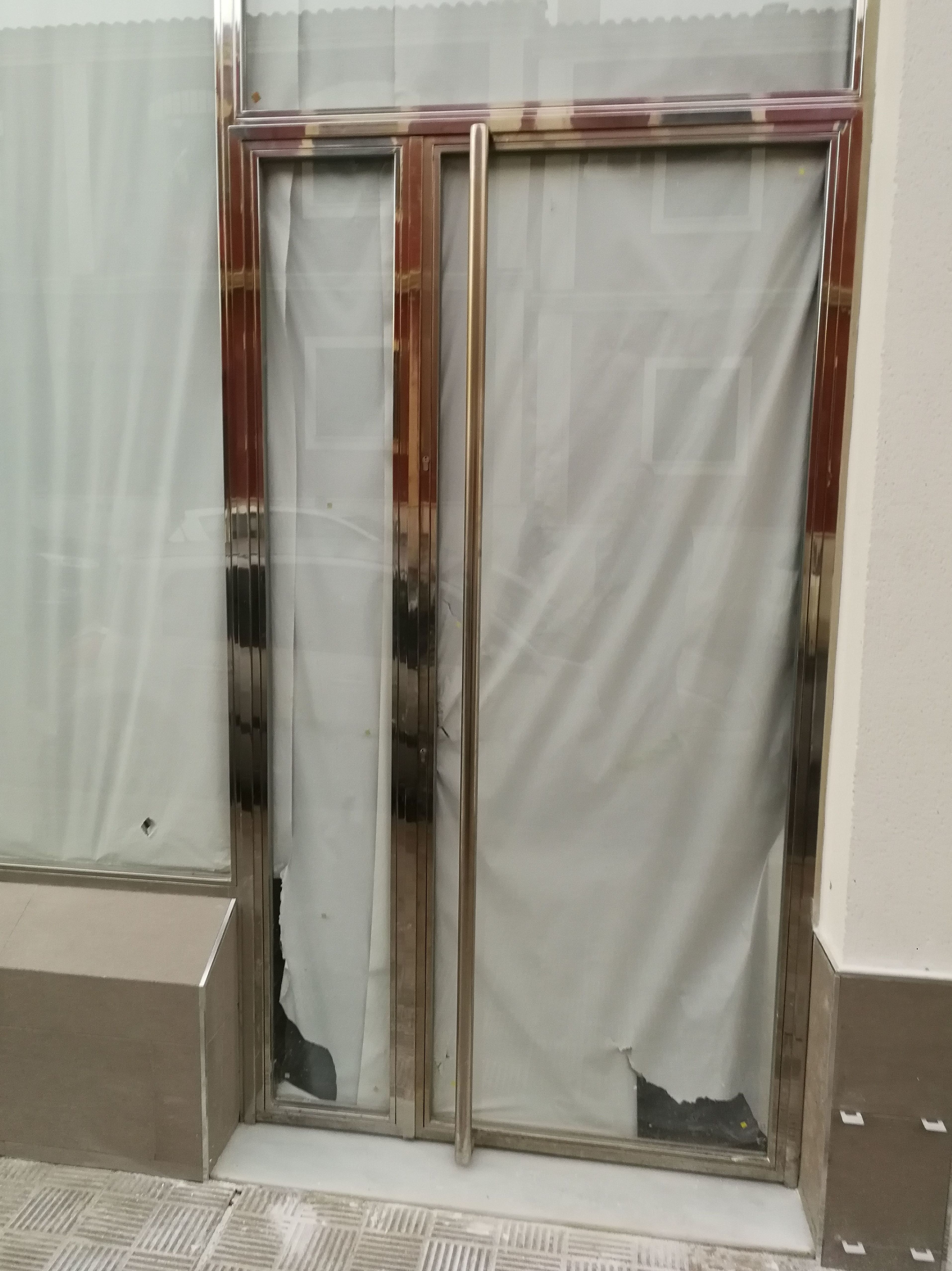 Puerta y escaparate de acero inoxidable y vidrio diseñada y fabricada a medida para local comercial. Puerta y escaparate de acero inoxidable y vidrio diseñada y fabricada a medida para local comercial.