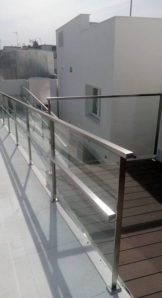 Barandillas de acero inoxidable y vidrio diseñada y montada en hotel para acceso a piscina.