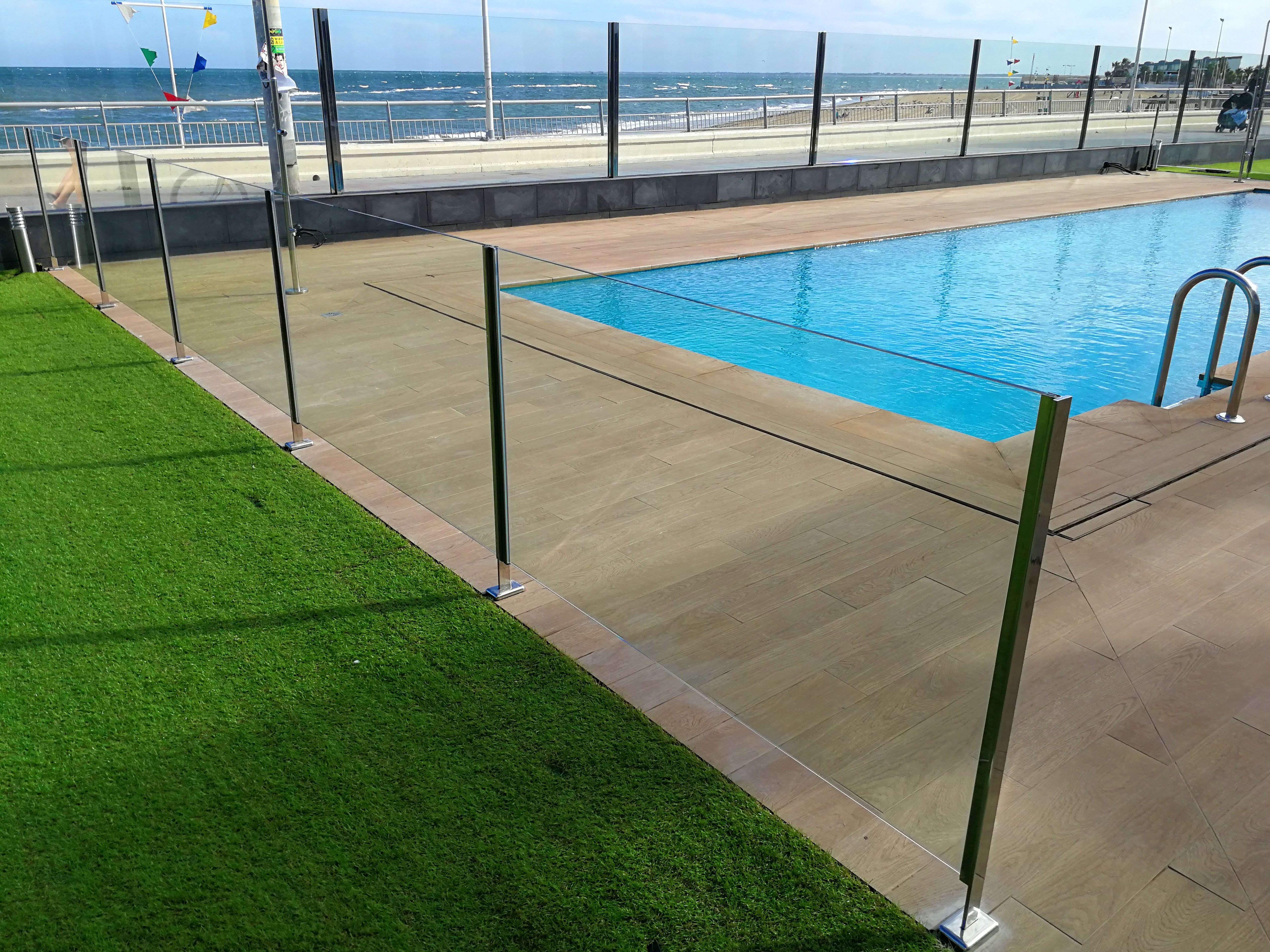 Barandilla de acero inoxidable y vidrio con puerta de acceso a piscina diseñada y fabricada a medida. Barandilla de acero inoxidable y vidrio con puerta de acceso a piscina diseñada y fabricada a medida.