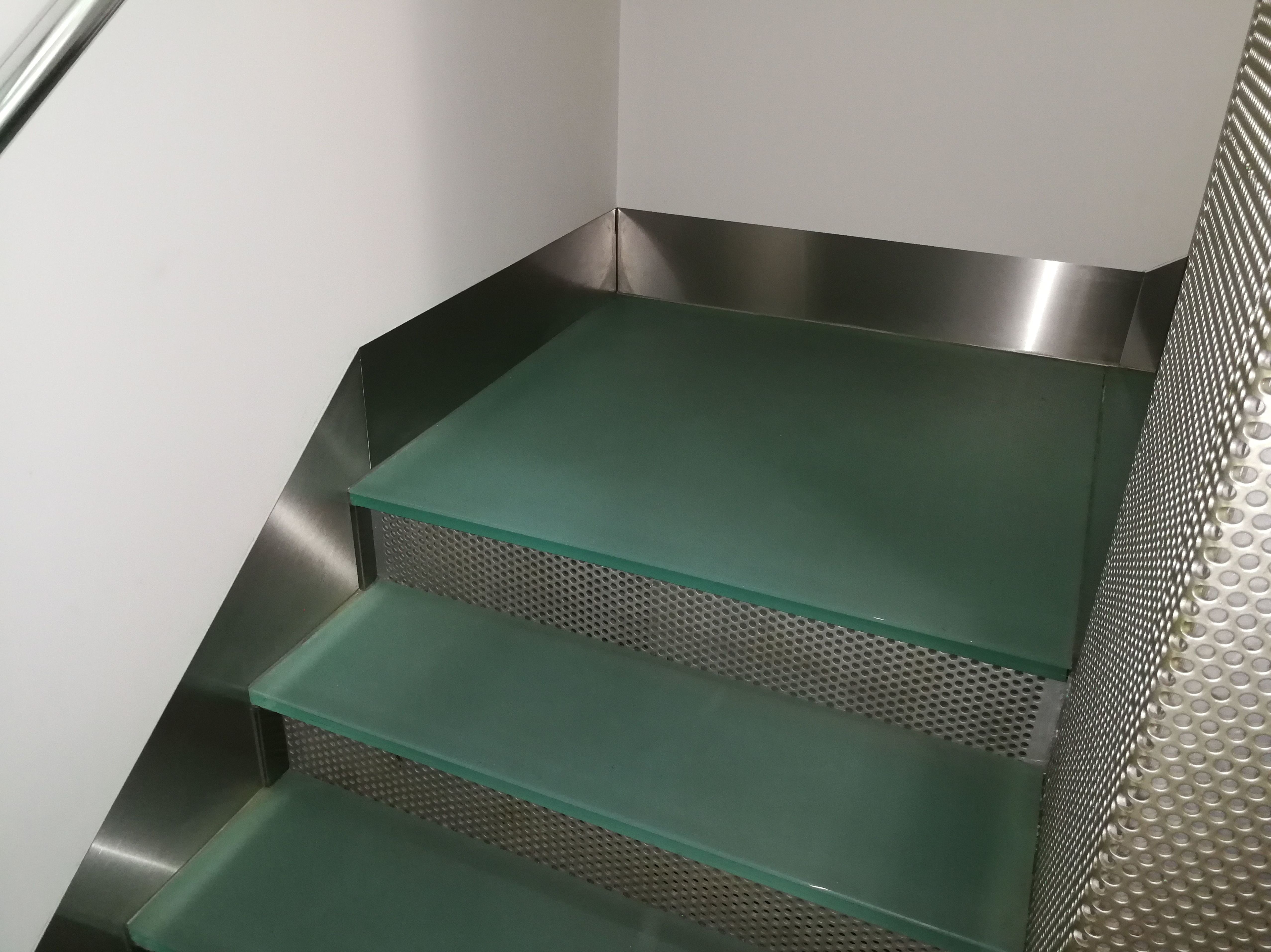 Zócalos de acero inoxidable diseñados y montados a medida para escalera de vidrio de hotel. Zócalos de acero inoxidable diseñados y montados a medida para escalera de vidrio de hotel.