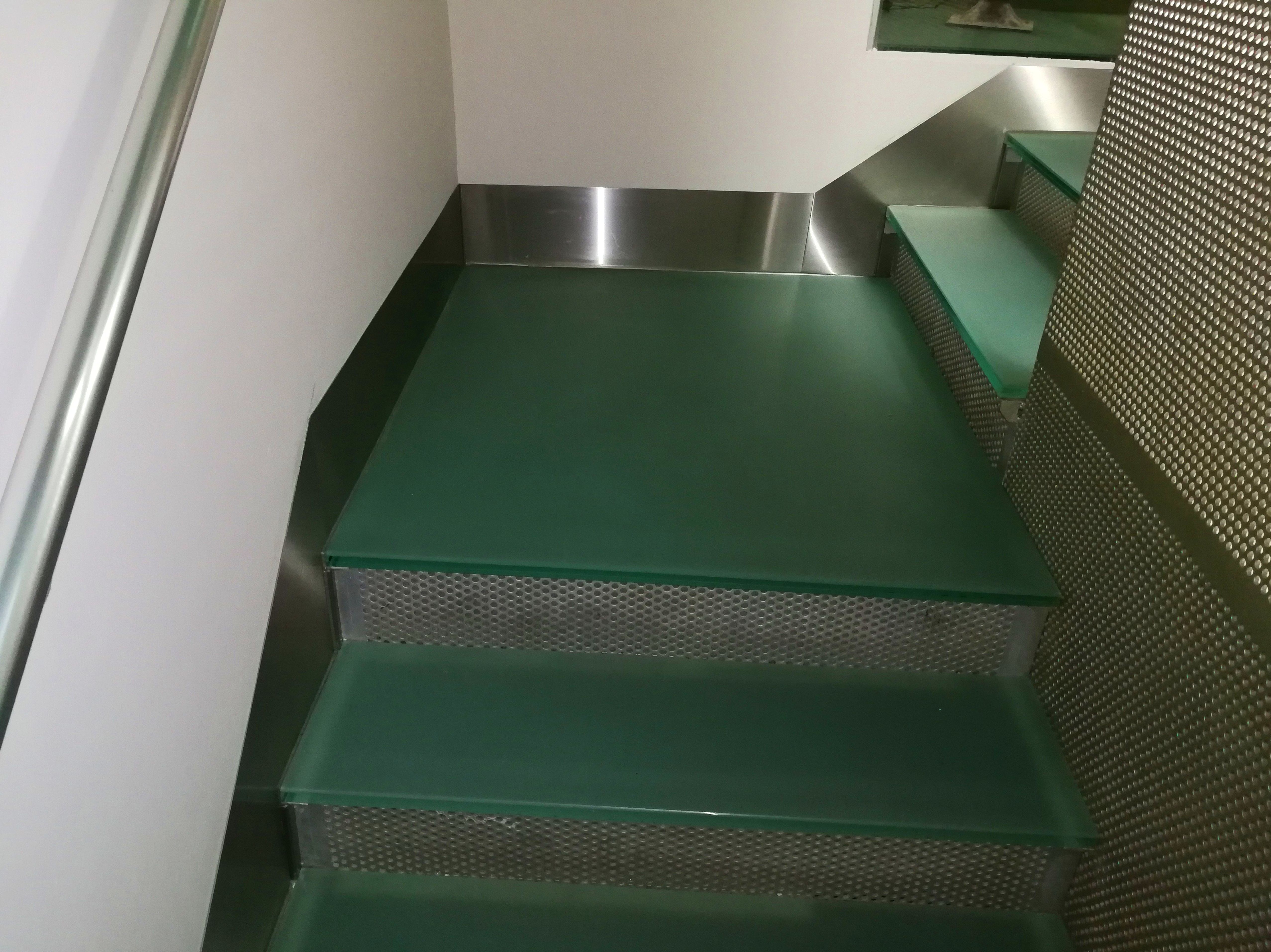 Zócalos de acero inoxidable diseñados y montados a medida para escalera de vidrio de hotel. Zócalos de acero inoxidable diseñados y montados a medida para escalera de vidrio de hotel.