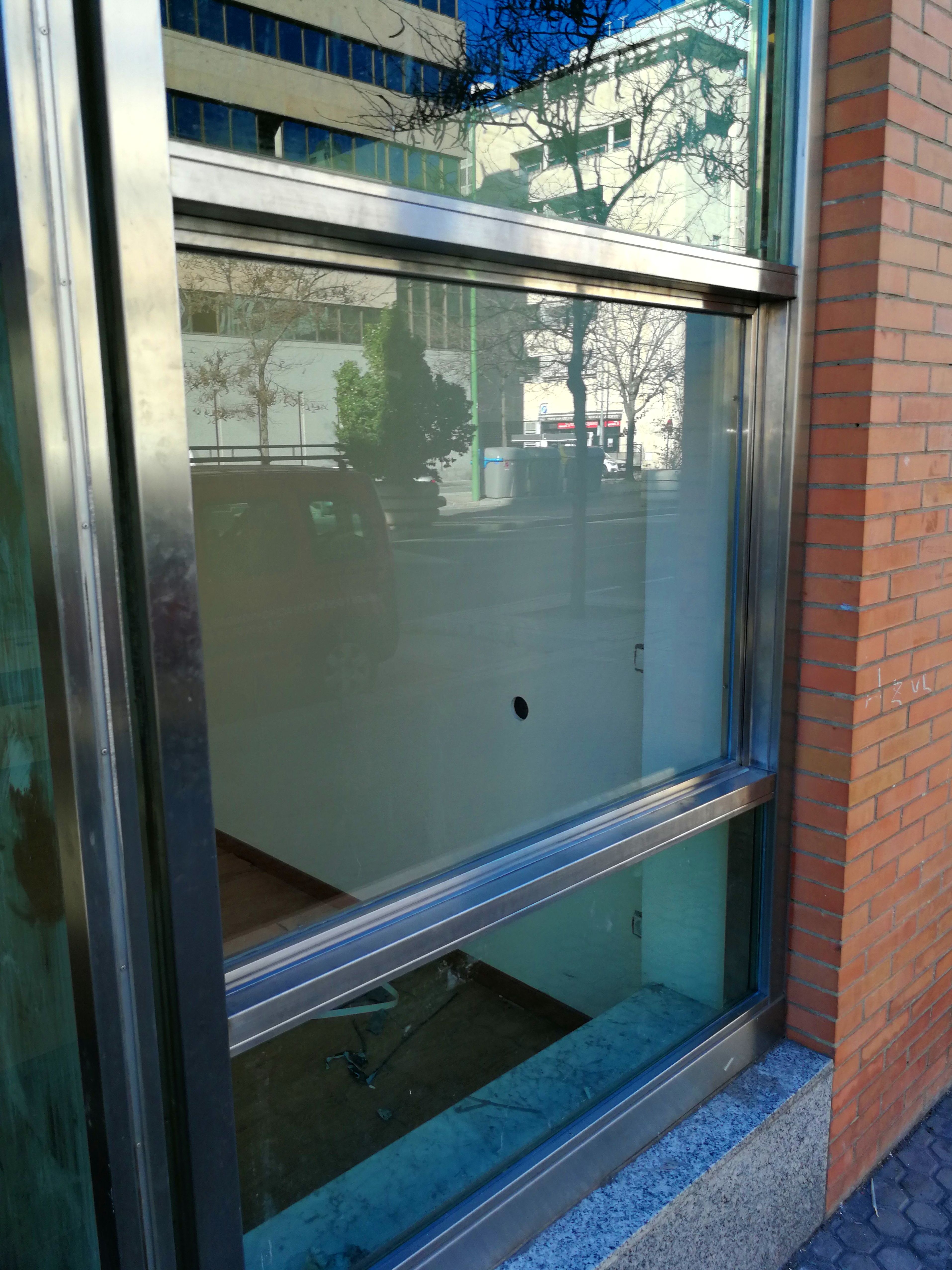 Ventana guillotina de acero inoxidable y vidrio montada para escaparate de local comercial. Ventana guillotina de acero inoxidable y vidrio montada para escaparate de local comercial.
