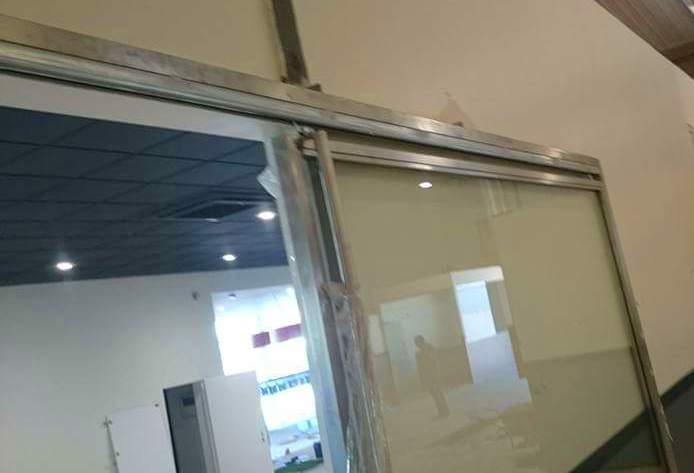 Puerta corredera de acero inoxidable y vidrio para acceso de vehículos en concesionario. Puerta corredera de acero inoxidable y vidrio para acceso de vehículos en concesionario.
