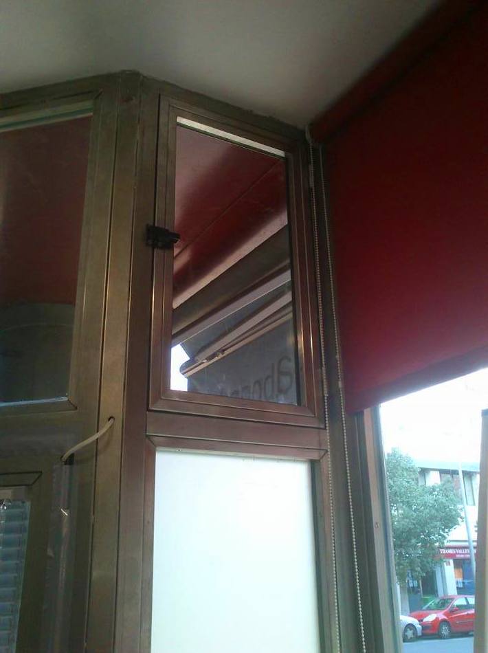 Ventana de acero inoxidable adaptada a puerta de acceso a comercio. Ventana de acero inoxidable adaptada a puerta de acceso a comercio.