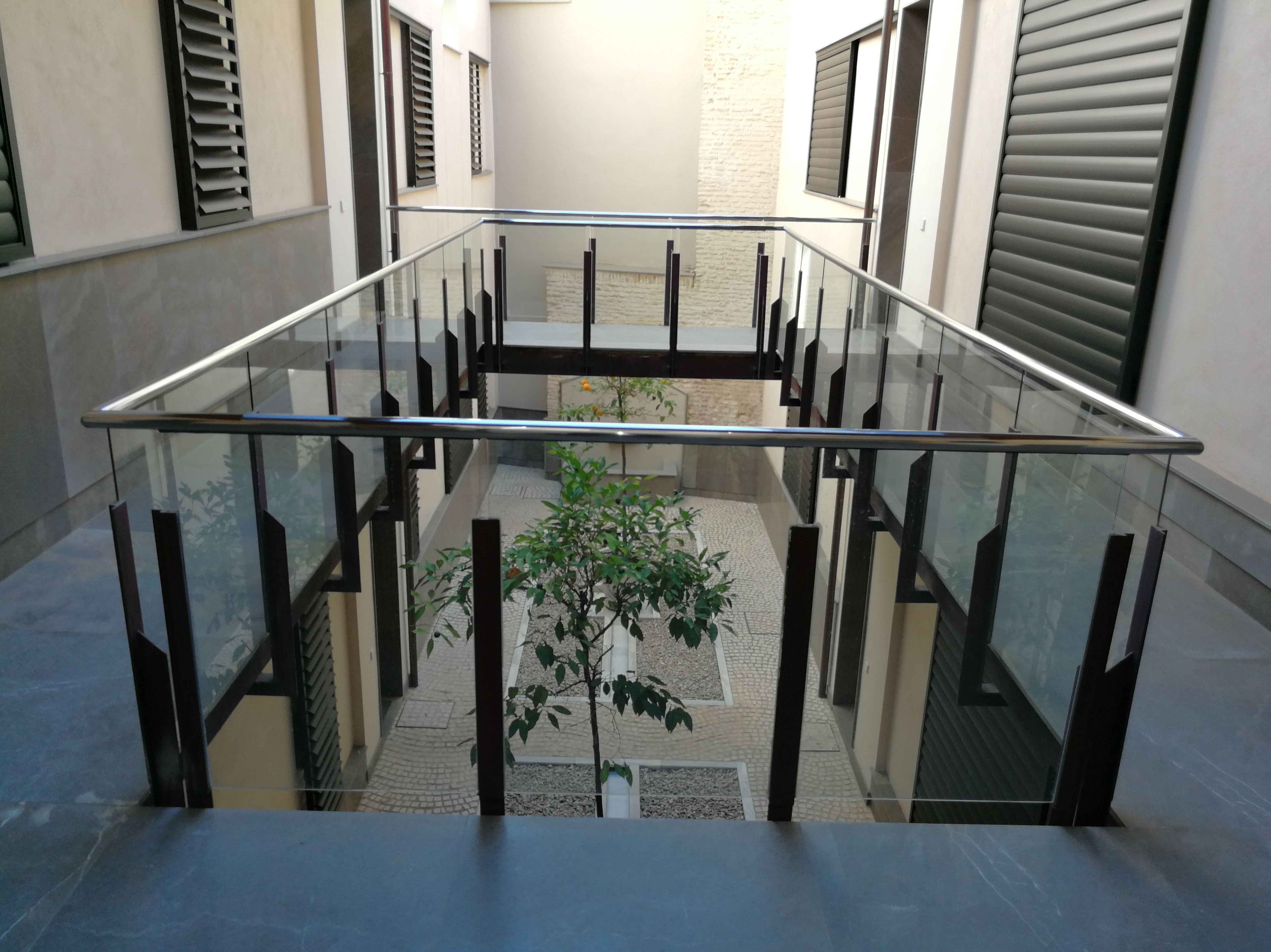 Pasamanos de acero inoxidable con alojamiento en vidrio para comunidad de vecinos. Pasamanos de acero inoxidable con alojamiento en vidrio para comunidad de vecinos.