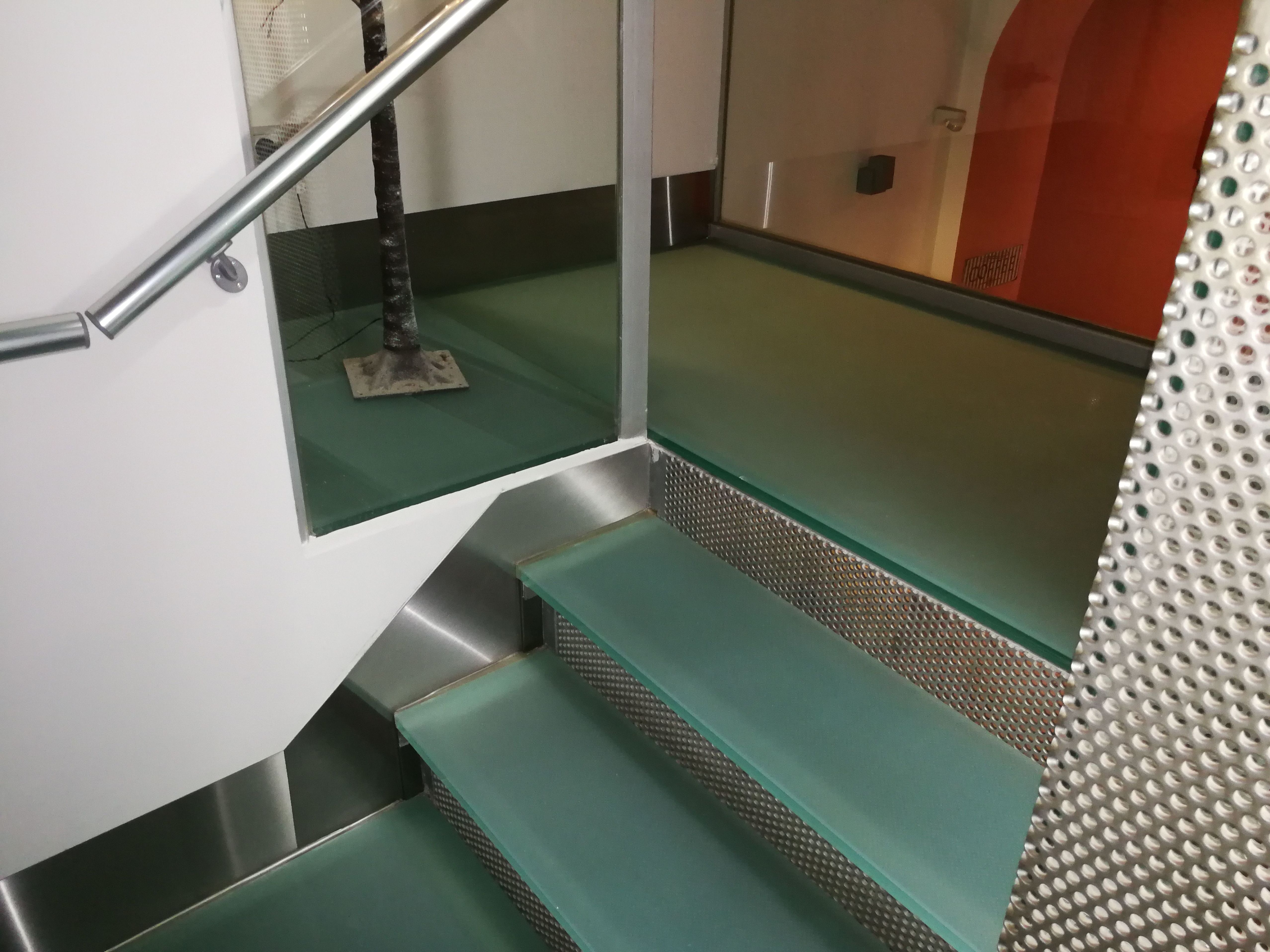 Zócalos de acero inoxidable diseñados y montados a medida para escalera de vidrio de hotel. Zócalos de acero inoxidable diseñados y montados a medida para escalera de vidrio de hotel.