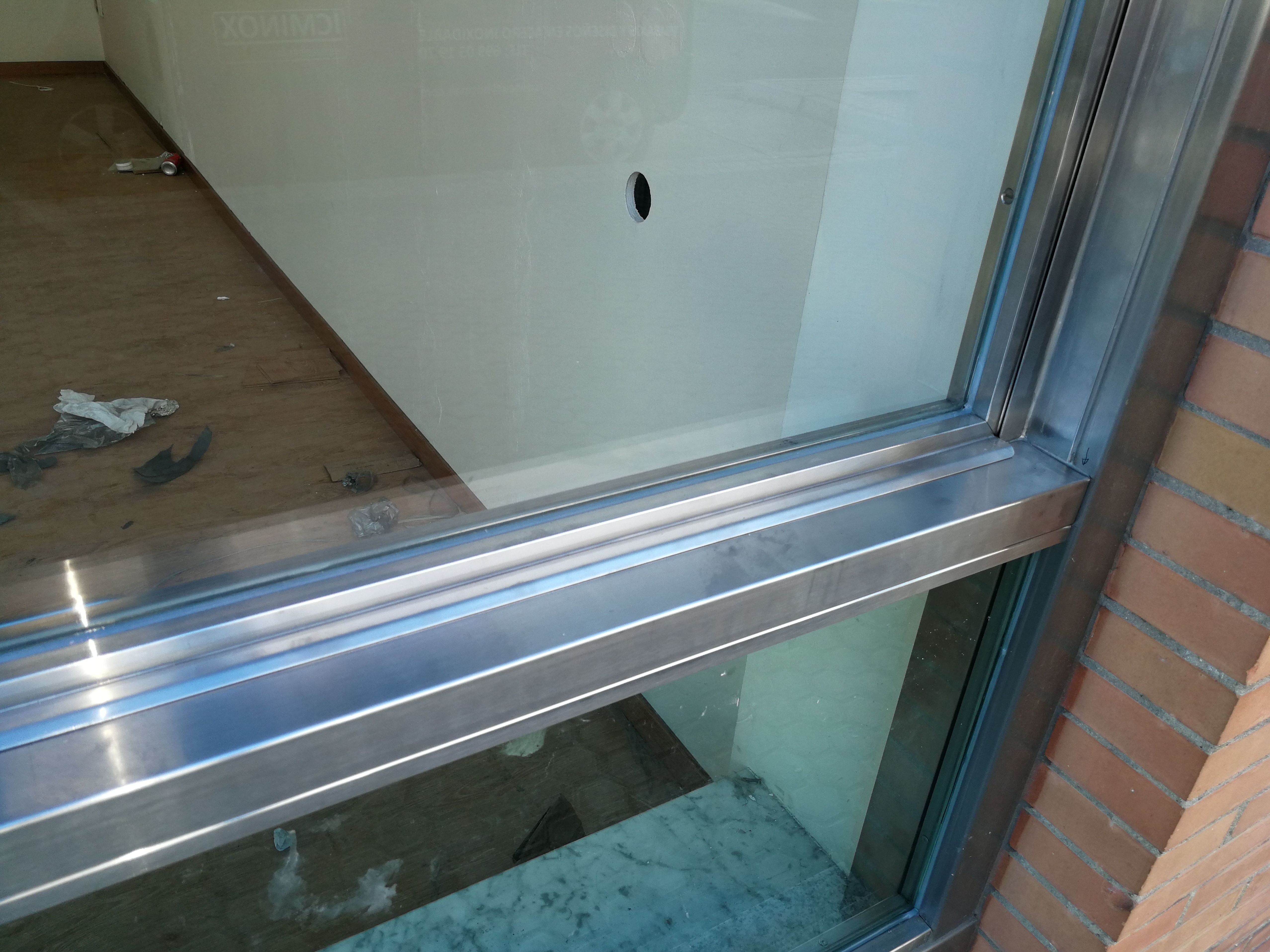Ventana guillotina de acero inoxidable y vidrio montada en escaparate comercial Ventana guillotina de acero inoxidable y vidrio montada en escaparate comercial