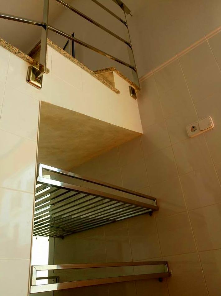 Estantería de acero inoxidable diseñada y fabricada a medida para hueco de escalera de garaje de vivienda particular. Estantería de acero inoxidable diseñada y fabricada a medida para hueco de escalera de garaje de vivienda particular.