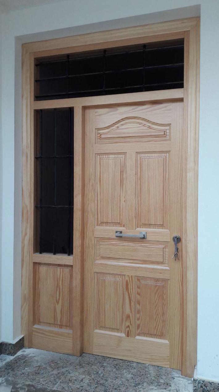 puerta de entrada de pino tea barnizada, con rejas de forja puerta de entrada de pino tea barnizada, con rejas de forja