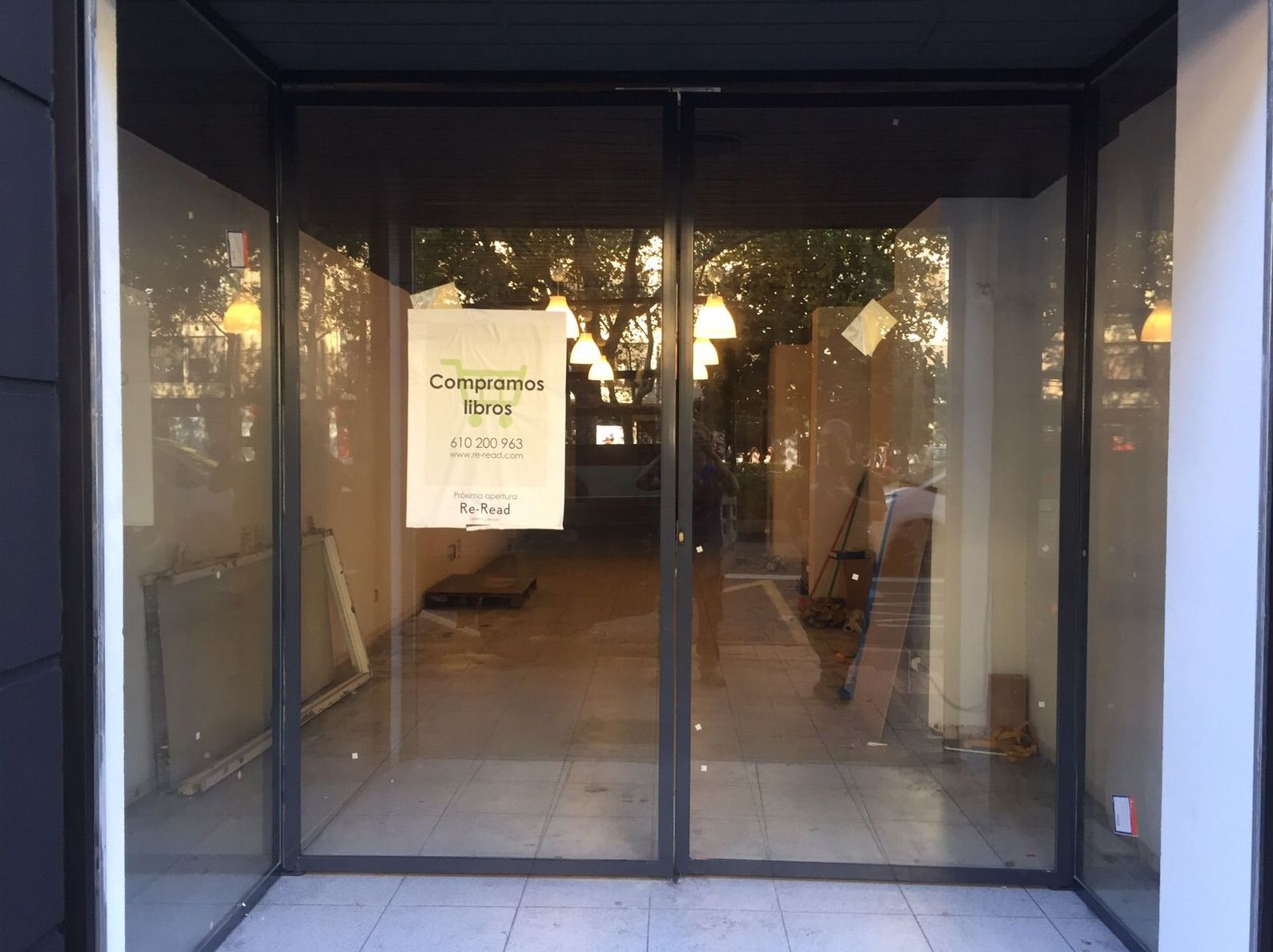 Entrada a tienda con puerta de dos hojas pivotantes de hierro lacado al horno y vidrio laminado Entrada a tienda con puerta de dos hojas pivotantes de hierro lacado al horno y vidrio laminado