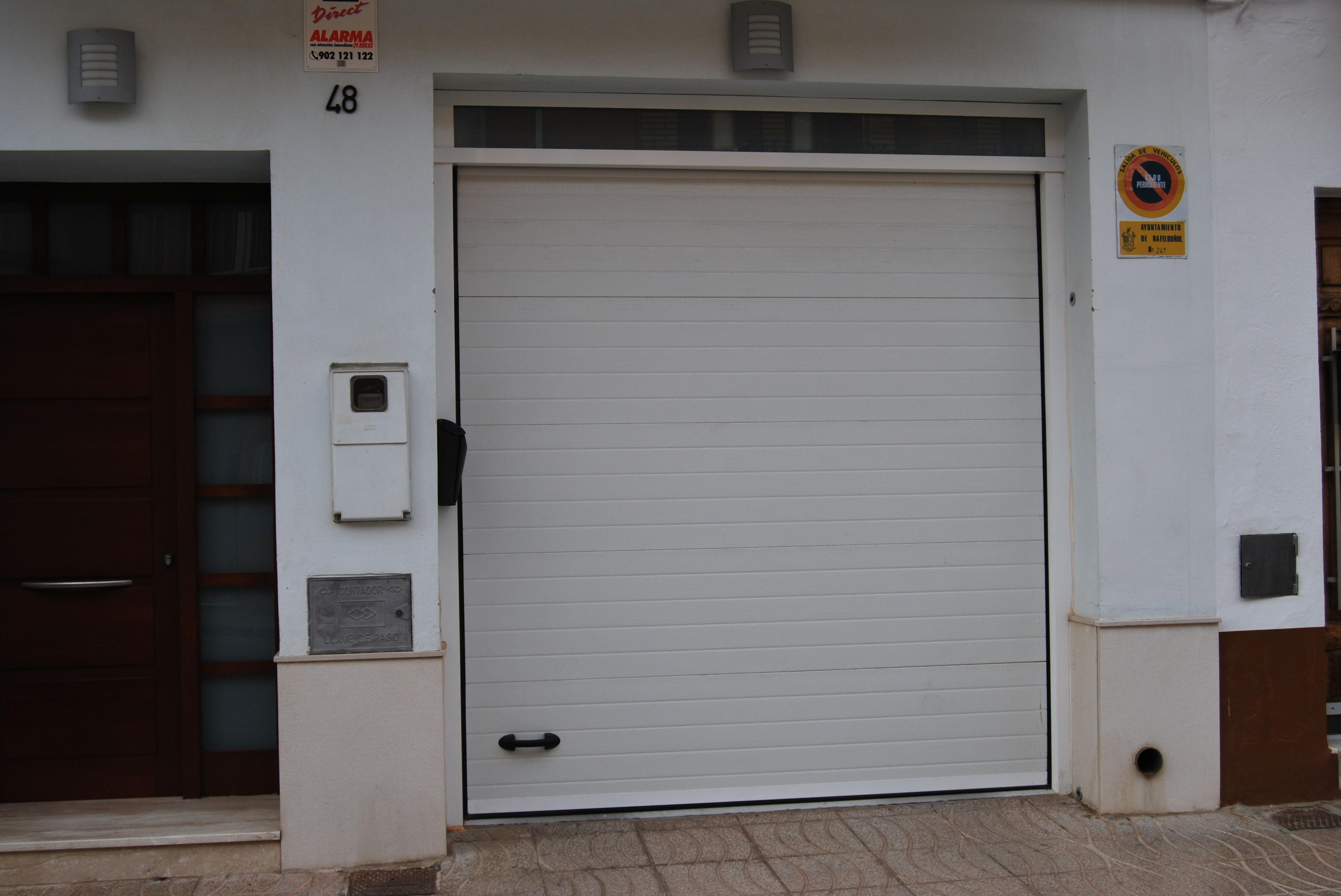 Puerta seccional de panel acanalado con fijo de vidrio superior. Puerta seccional de panel acanalado con fijo de vidrio superior.