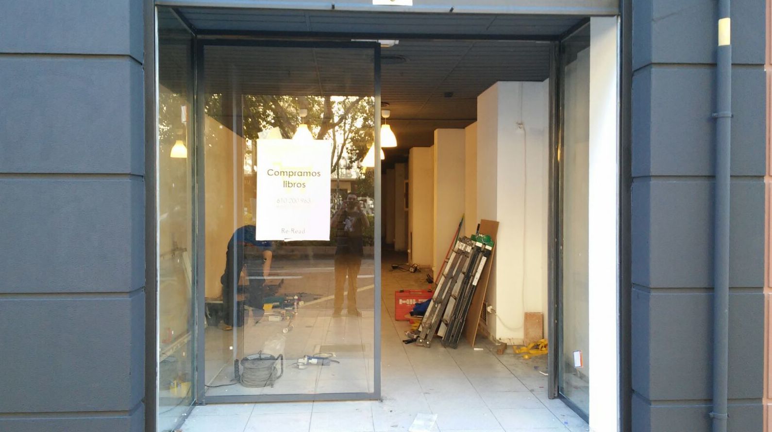 Entrada a tienda con puerta de dos hojas pivotantes de hierro lacado al horno y vidrio laminado Entrada a tienda con puerta de dos hojas pivotantes de hierro lacado al horno y vidrio laminado