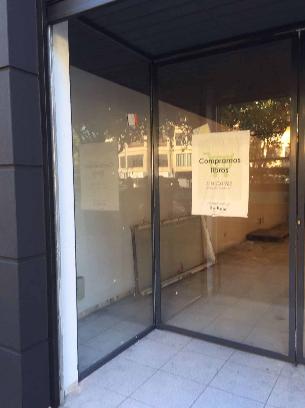 Entrada a tienda con puerta de dos hojas pivotantes de hierro lacado al horno y vidrio laminado Entrada a tienda con puerta de dos hojas pivotantes de hierro lacado al horno y vidrio laminado