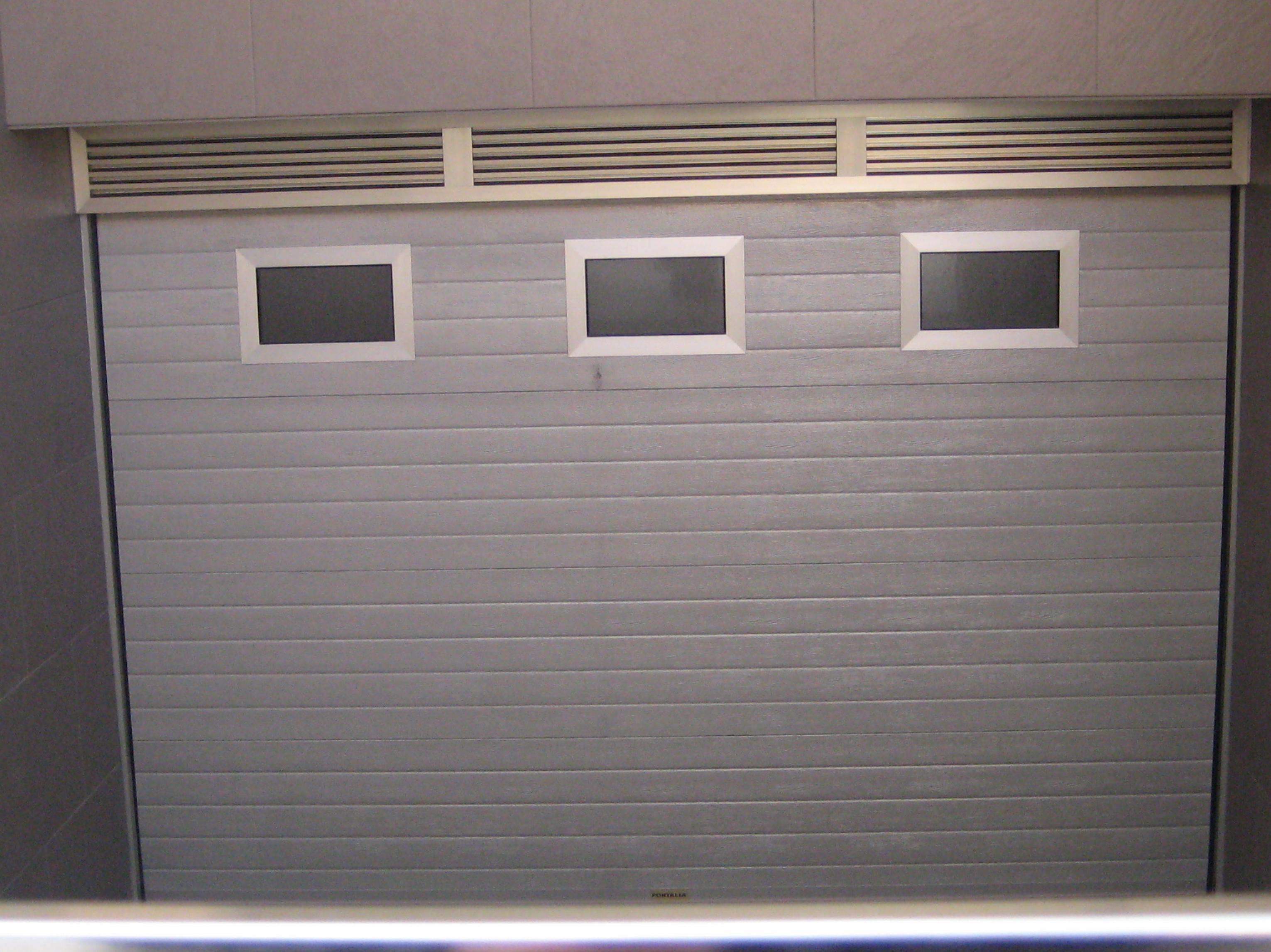 Puerta seccional con panel acanalado imitacion inox con celosia de ventilacion superior. Puerta seccional con panel acanalado imitacion inox con celosia de ventilacion superior.