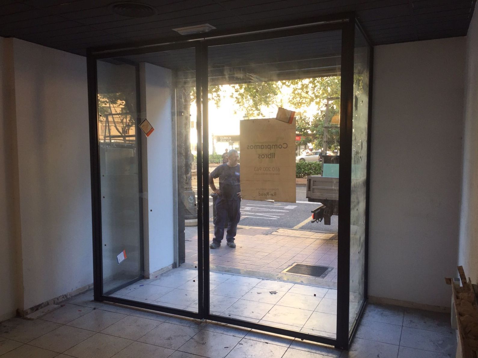 Entrada a tienda con puerta de dos hojas pivotantes de hierro lacado al horno y vidrio laminado Entrada a tienda con puerta de dos hojas pivotantes de hierro lacado al horno y vidrio laminado