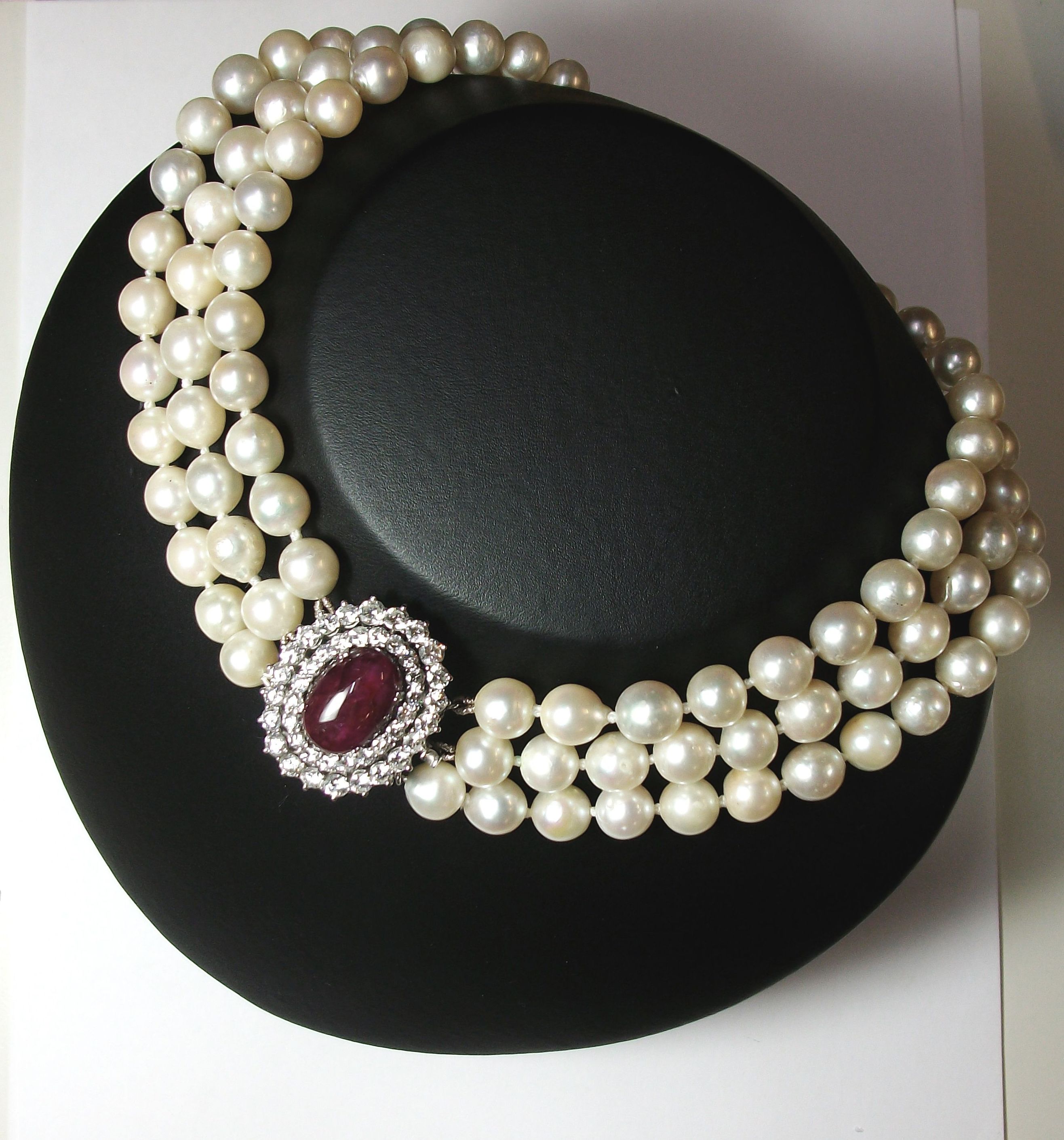 Collar de perlas cultivadas con cierre oval compuesto por un gran cabujón de rubí y dos orlas de brillantes. Circa: 1960-1970.