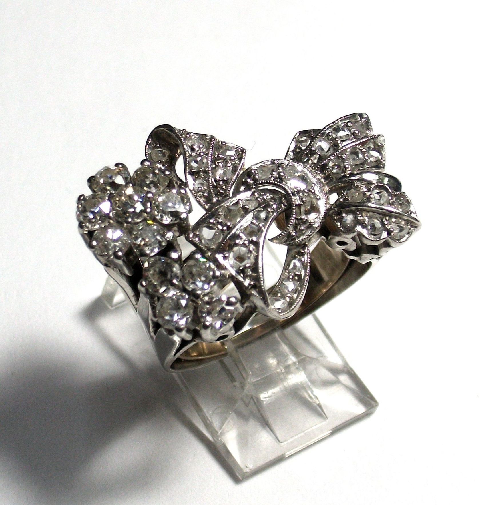 Sortija de platino y diamantes con forma de lazada y flores. 1930-40.: Catálogo de Antigua Joyeros Sortija de platino y diamantes con forma de lazada y flores. 1930-40.: Catálogo de Antigua Joyeros