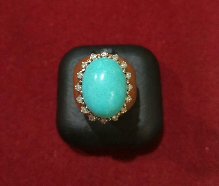 Sortija de oro de 18k con orla de brillantes y cabujón de turquesa. 1950-60: Catálogo de Antigua Joyeros Sortija de oro de 18k con orla de brillantes y cabujón de turquesa. 1950-60: Catálogo de Antigua Joyeros