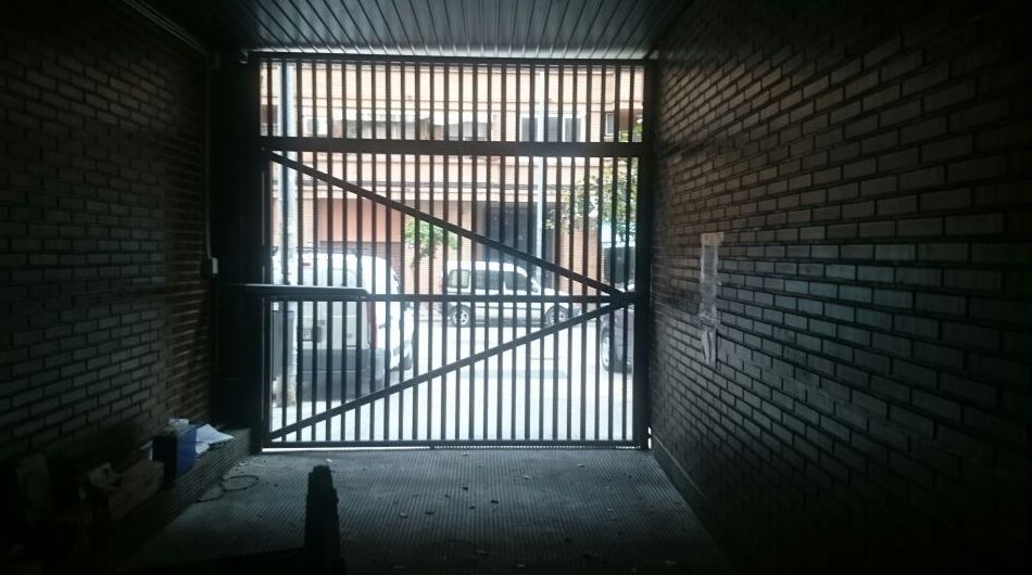 Puerta batiente en garaje comunitario. Lama microperforada y fijo superior de la misma lama. Motor de uso intensivo. Puerta batiente en garaje comunitario. Lama microperforada y fijo superior de la misma lama. Motor de uso intensivo.