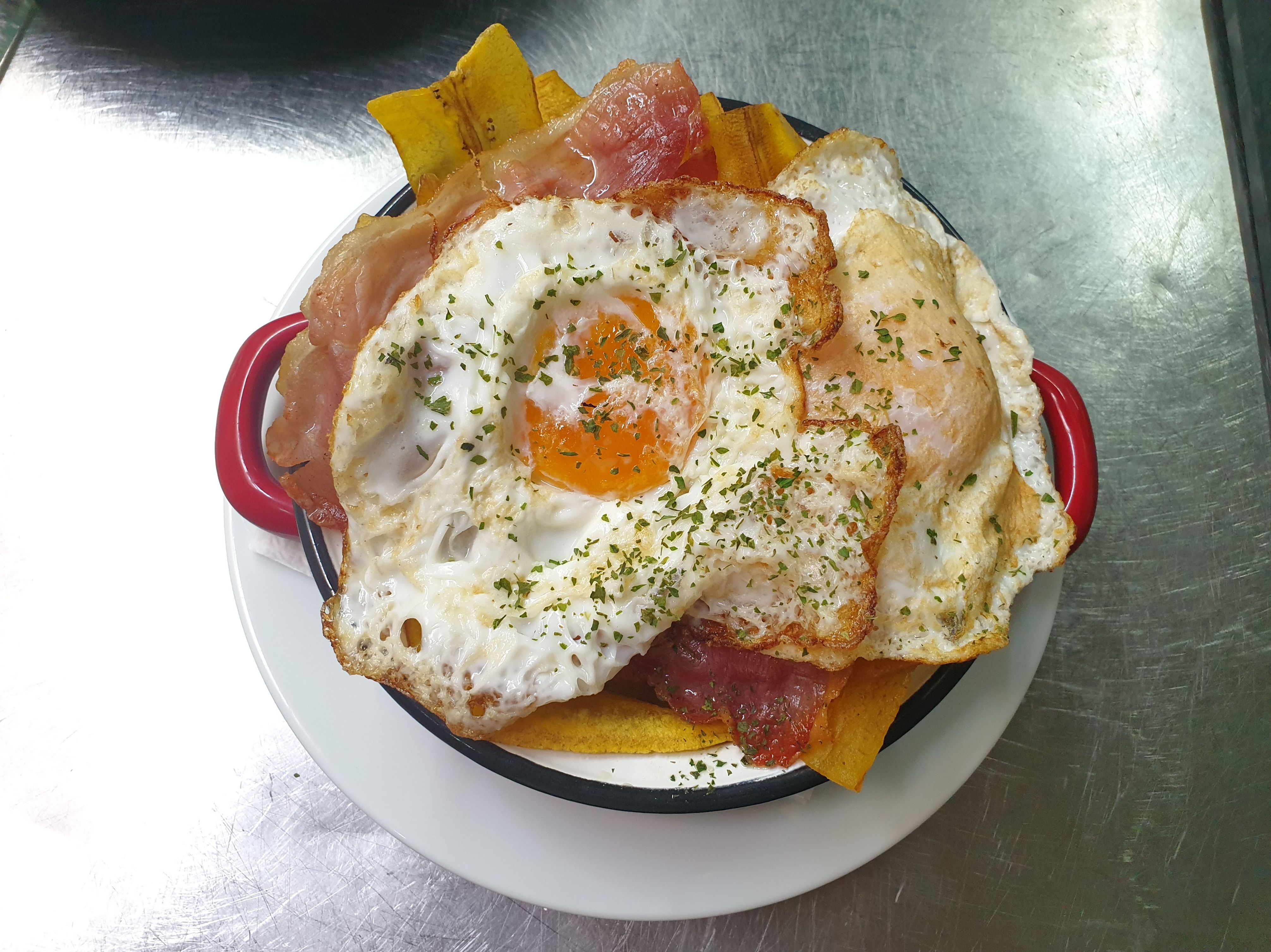 Sartén de huevos rotos, jamón y chips de plátano macho Sartén de huevos rotos, jamón y chips de plátano macho