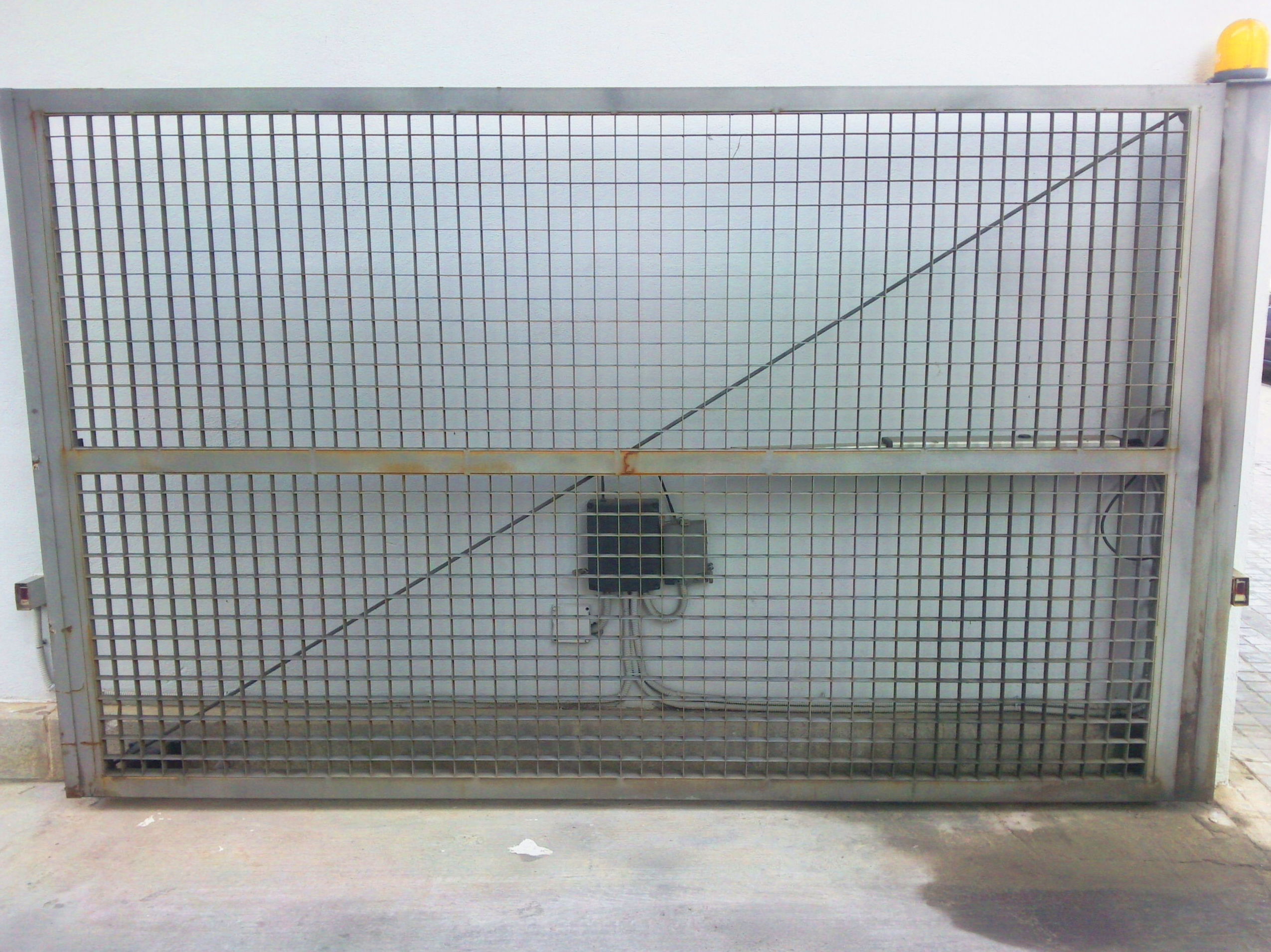 Puerta metálica batiente automática de rejilla ventilada 
